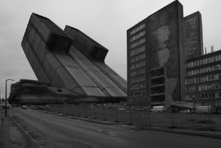 A black and white image of concrete tower blocks which are built at odd angles, as if part of an alien superstructure